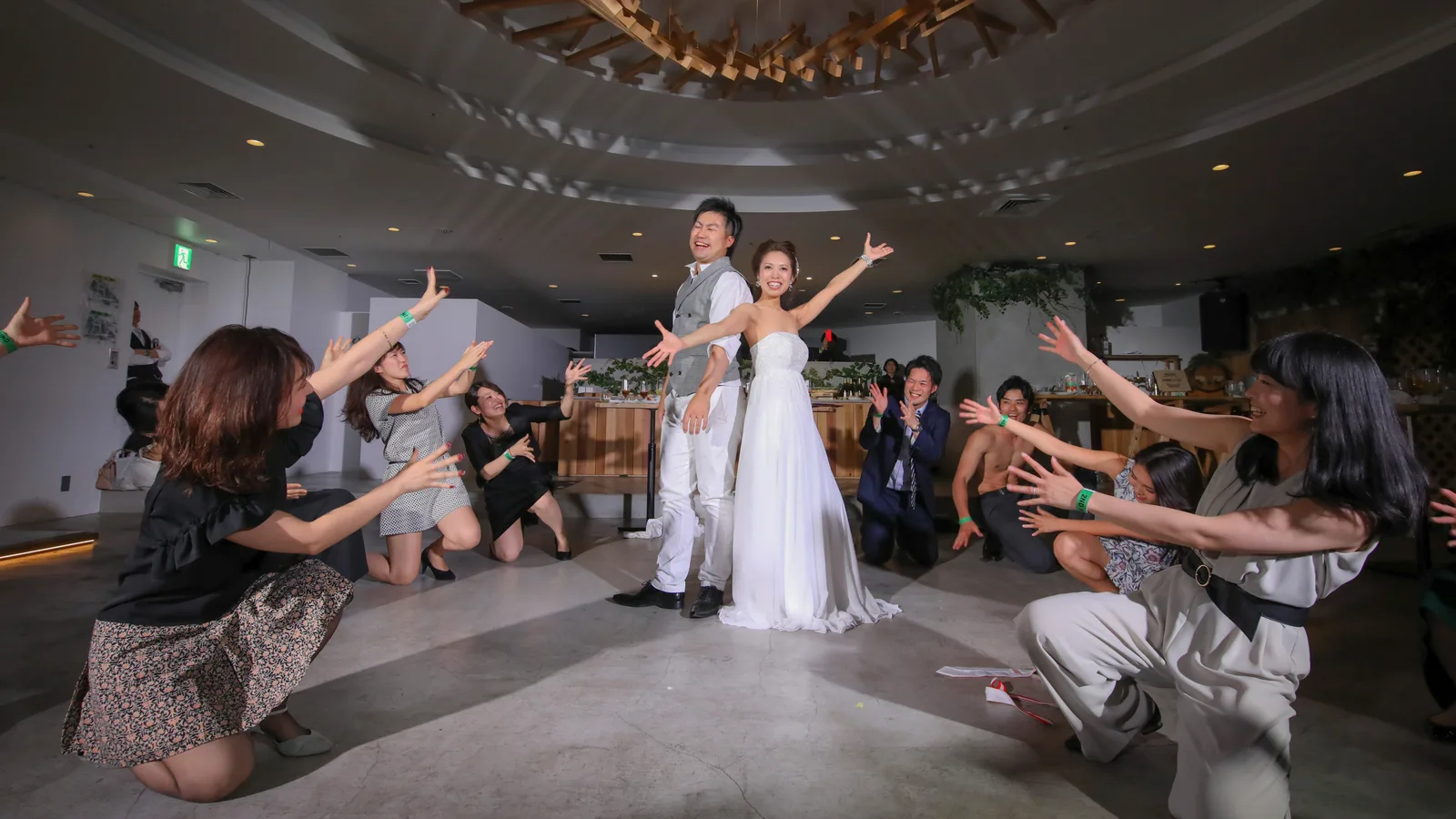 結婚式二次会で新郎新婦を囲んで盛り上がるゲスト