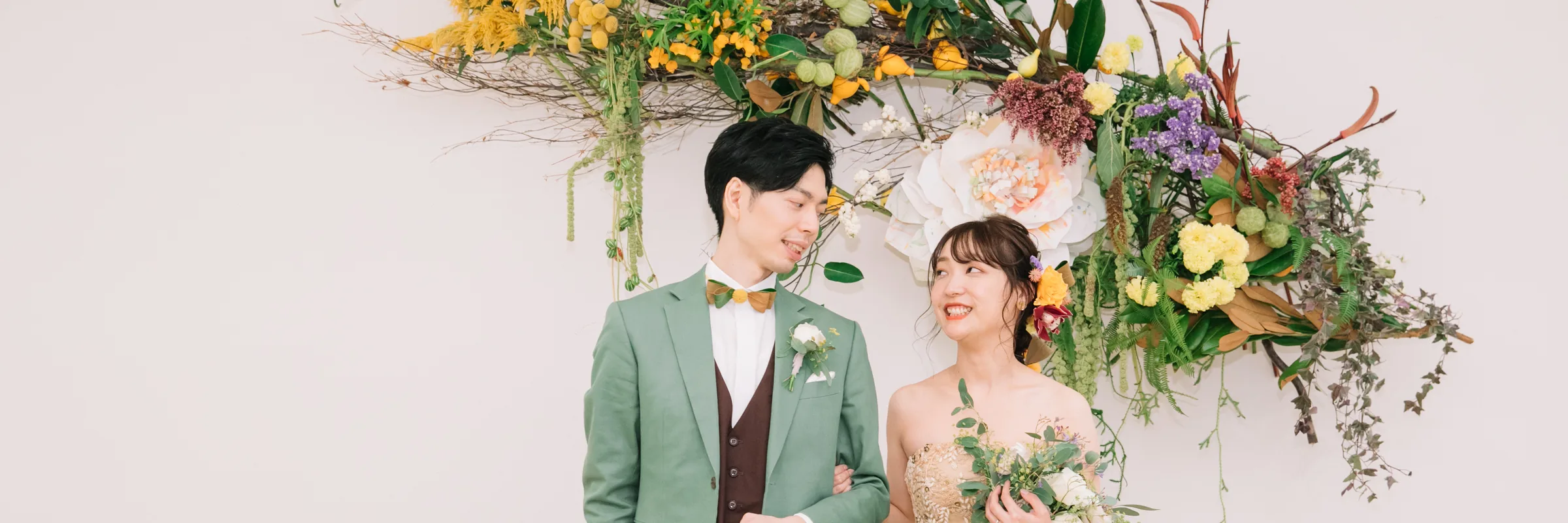 花に囲まれて寄り添う結婚式二次会・1.5次会の新郎新婦