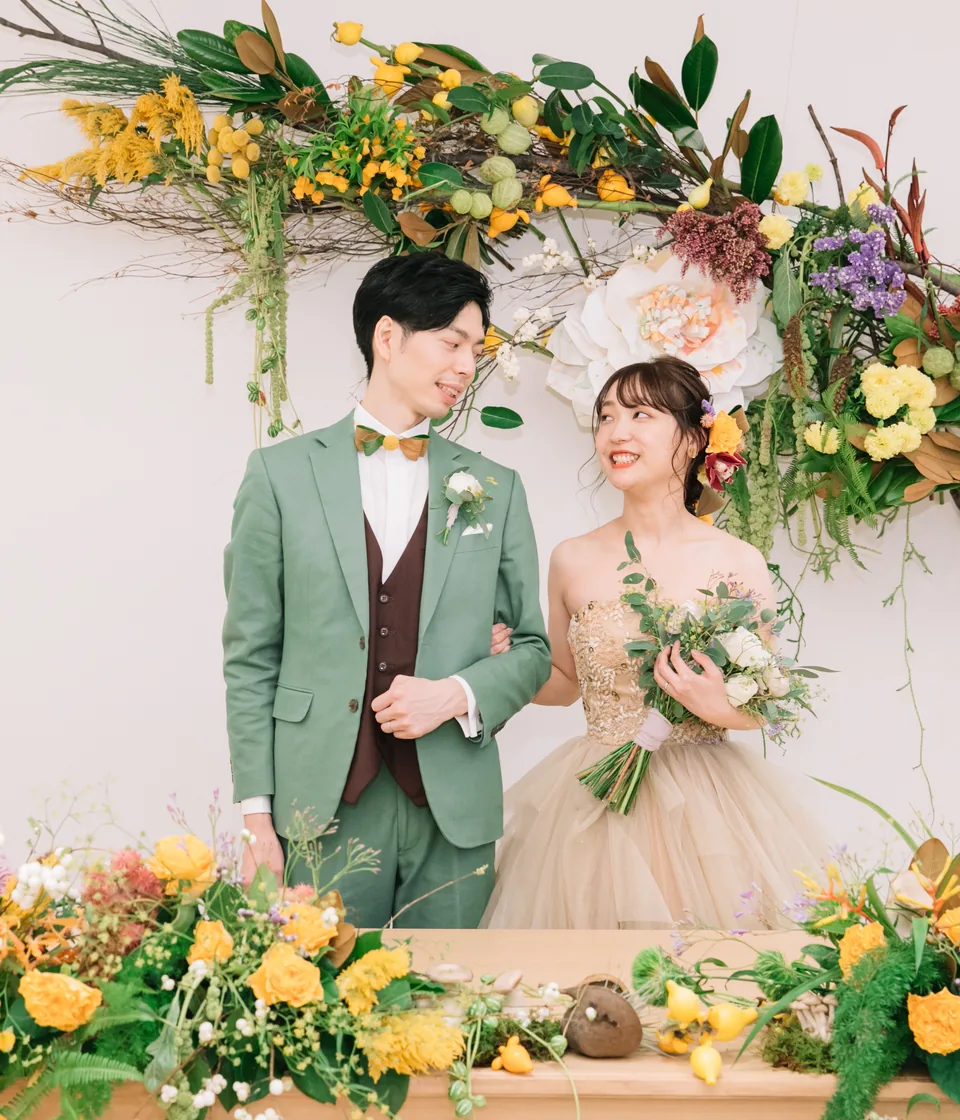 花に囲まれて寄り添う結婚式二次会の新郎新婦